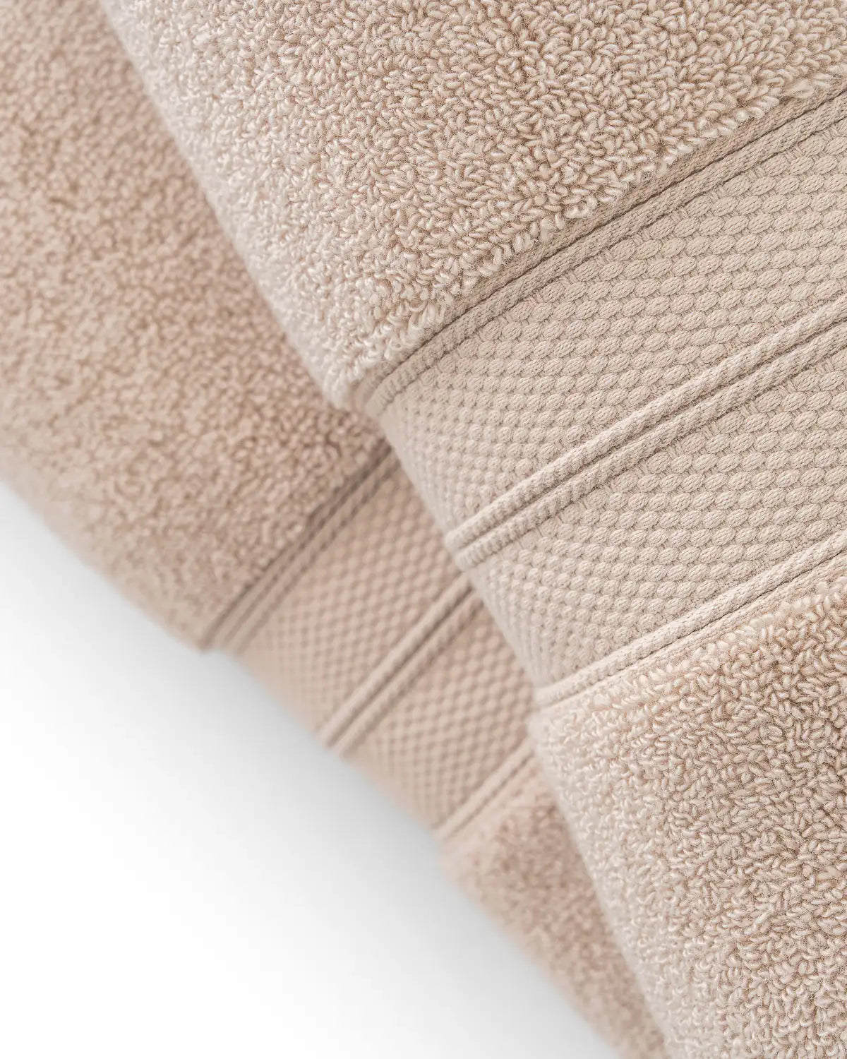 Close-up of sandshell modal cotton premium towels with textured surface on a light gray background