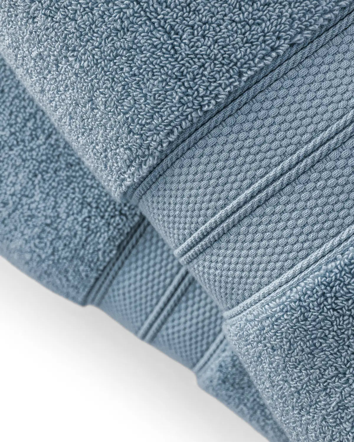 Close-up of blue shadow modal cotton premium towels with textured surface on a white background