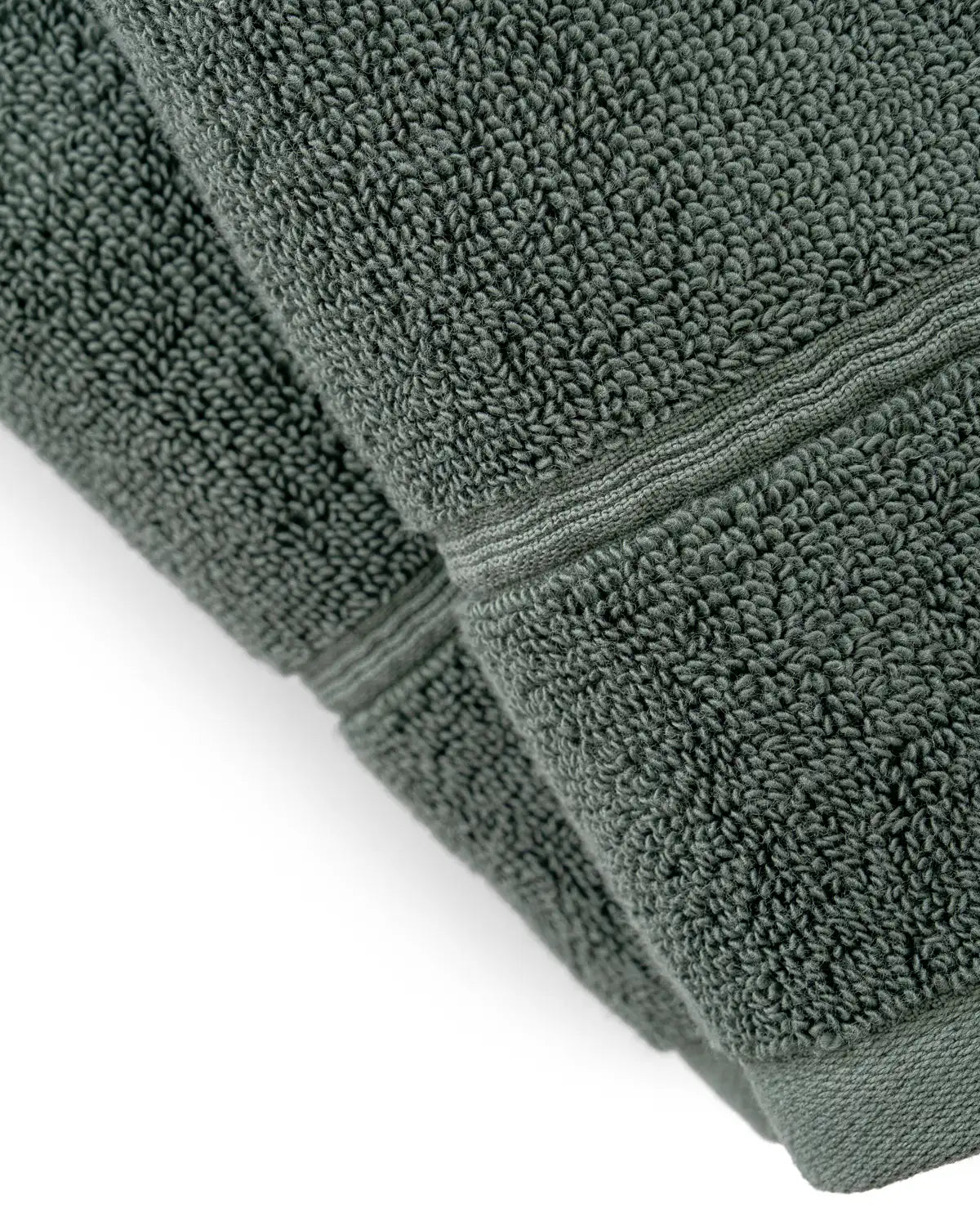 Stack of pine green Turkish cotton towels on a white background