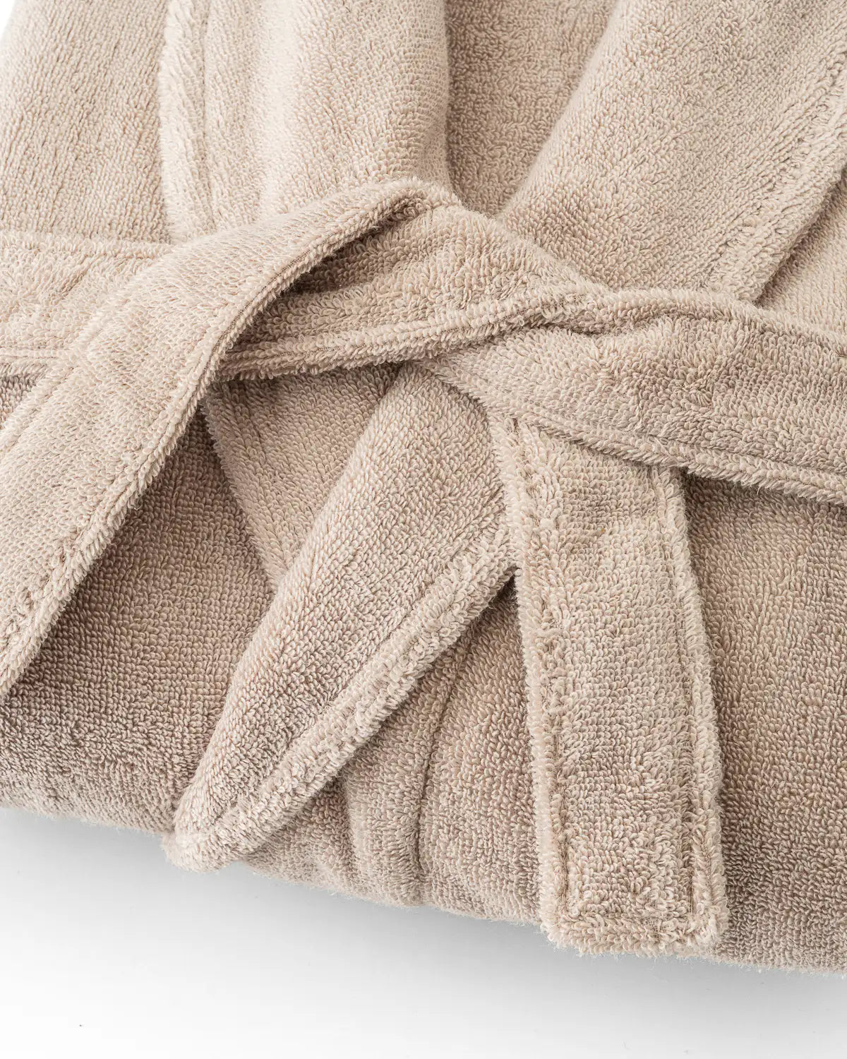 Close-up of a sandshell ultrasoft premium bathrobe with a belt on a white background
