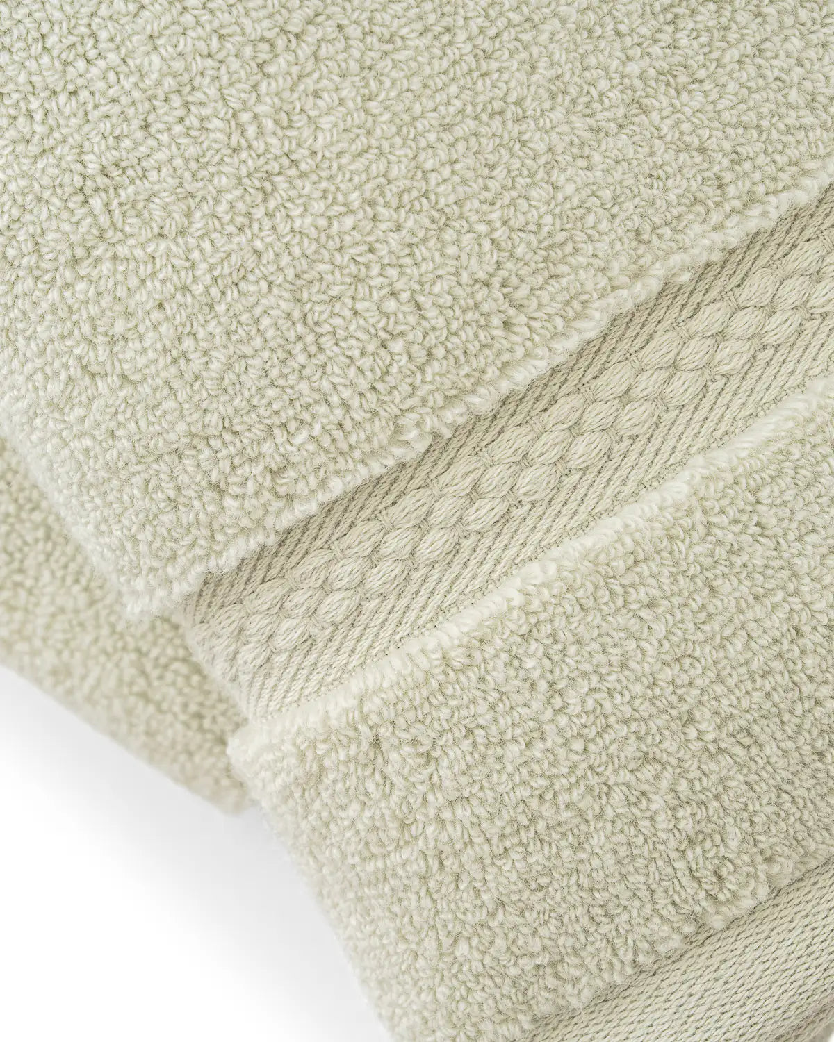 Close-up of jade ultrasoft premium cotton towels with a textured surface on a white background