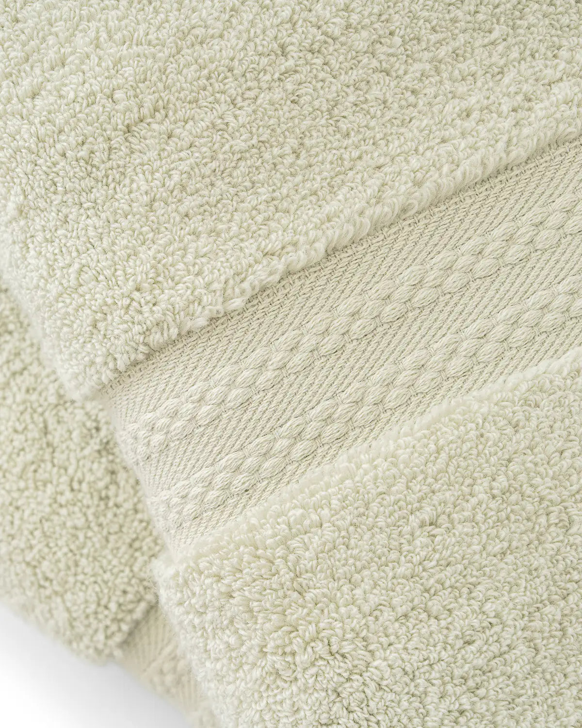 Close-up of a textured jade ultrasoft premium cotton towel with a folded edge.