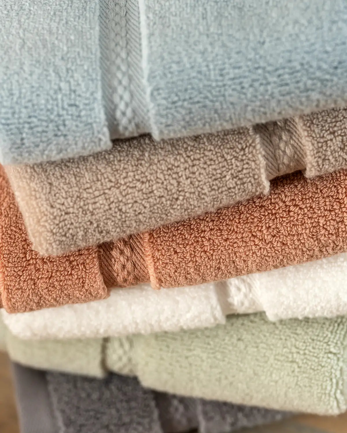 Stack of folded ultrasoft premium cotton washcloth towels in various colors