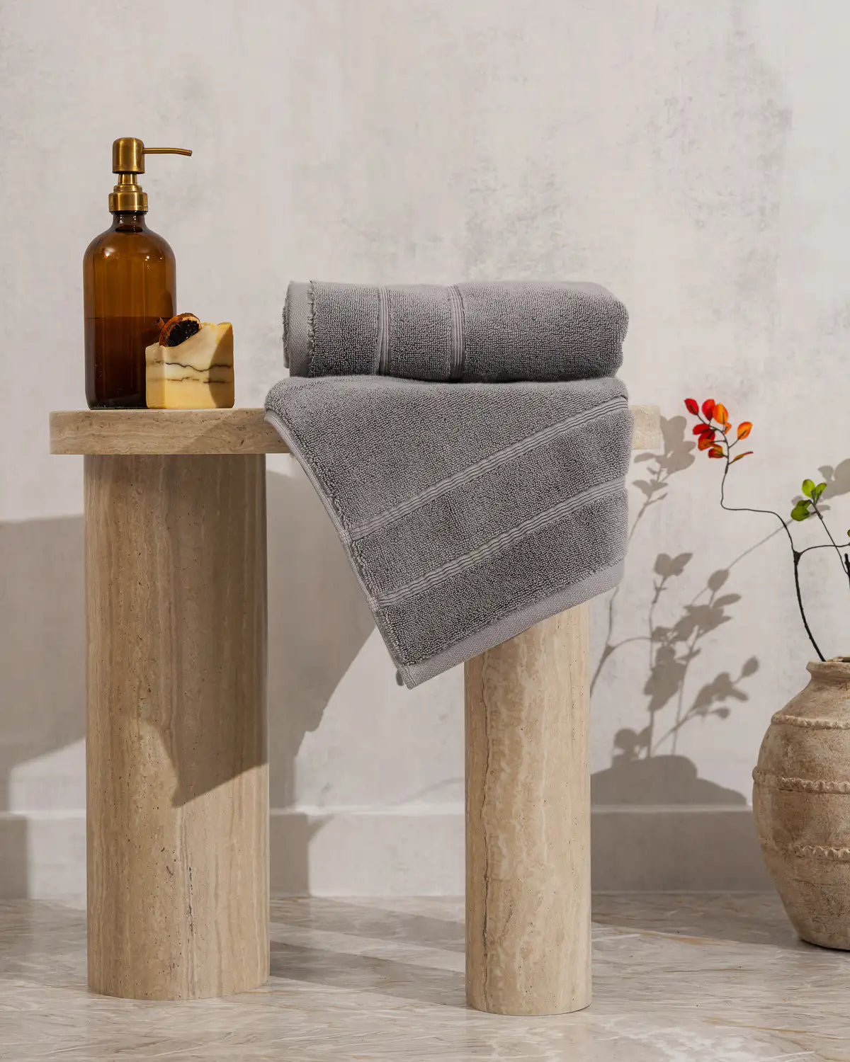 An opal gray classic Turkish bath towel resting on an elegant decorative surface.