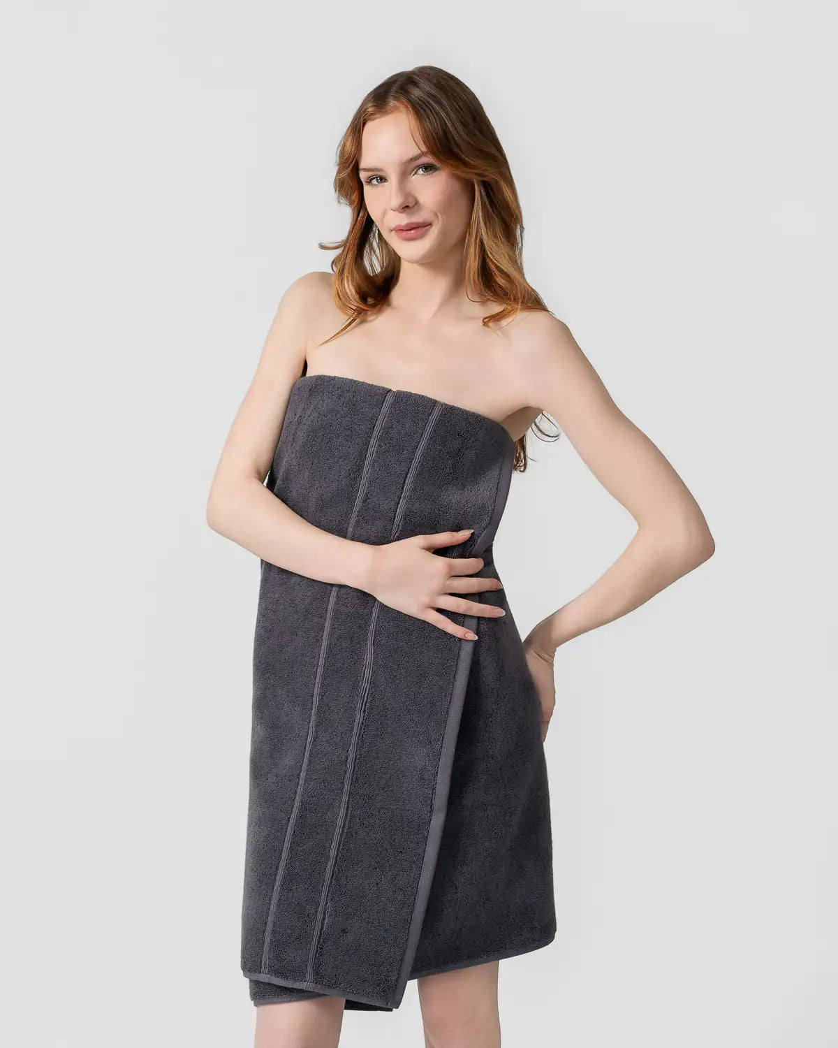 Woman wearing a tornado gray classic Turkish towel as a dress on a white background