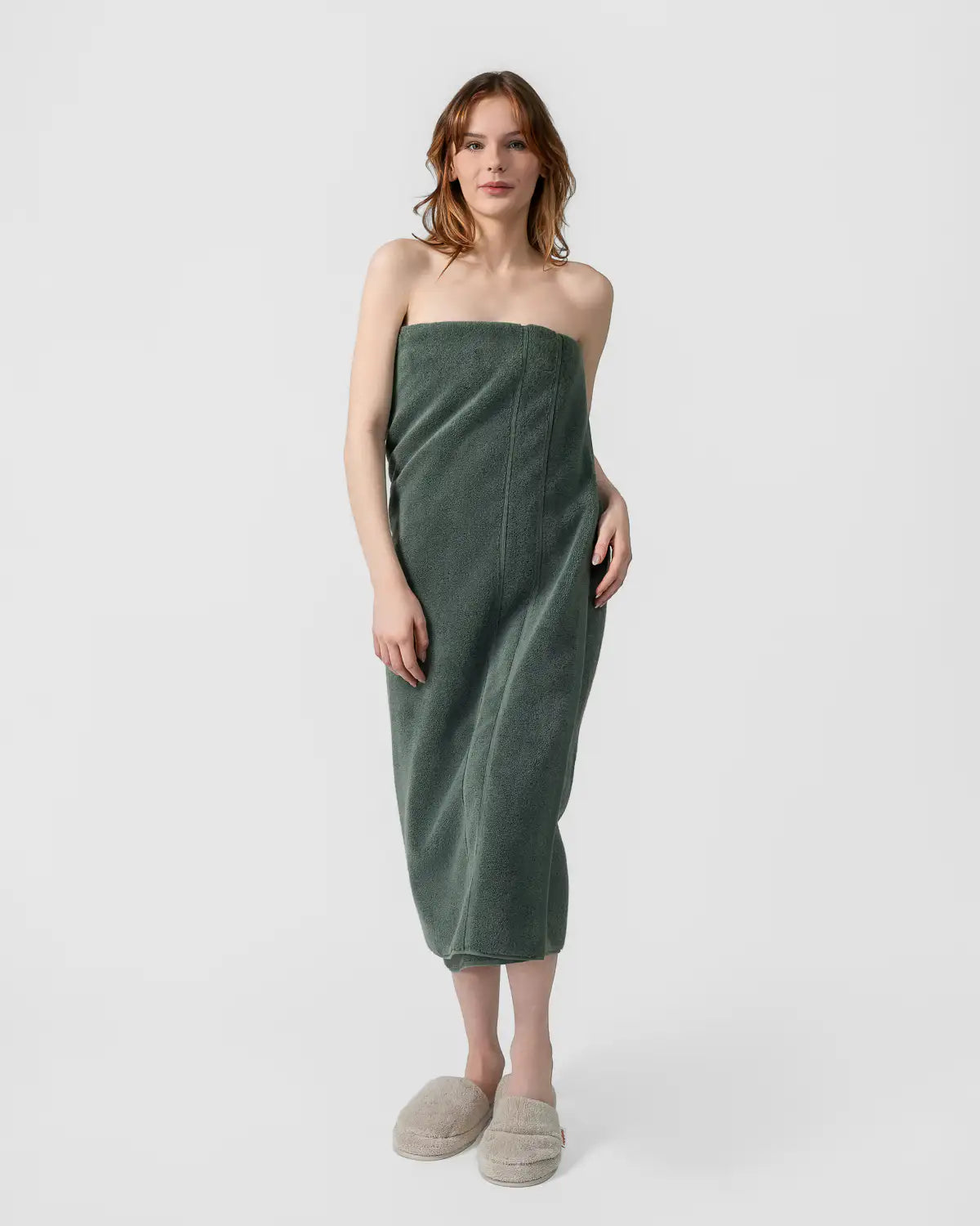 Woman wearing a pine green classic Turkish towel wrap on a white background
