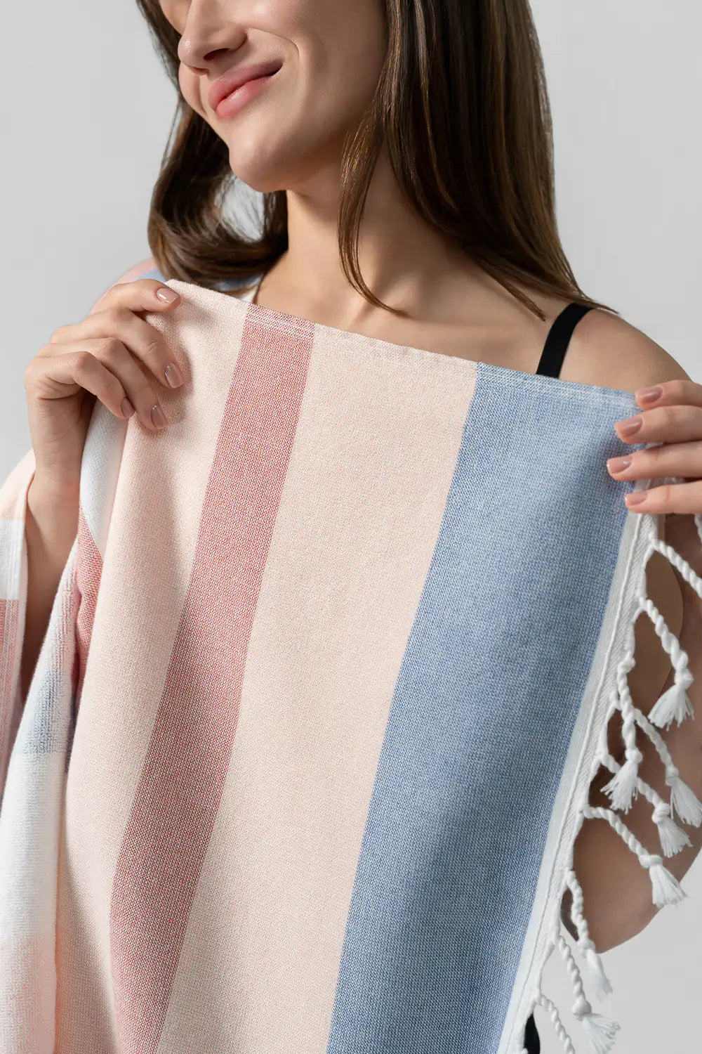 Woman holding a apricot color Soft Gradient Striped Beach & Pool Towel with a neutral background