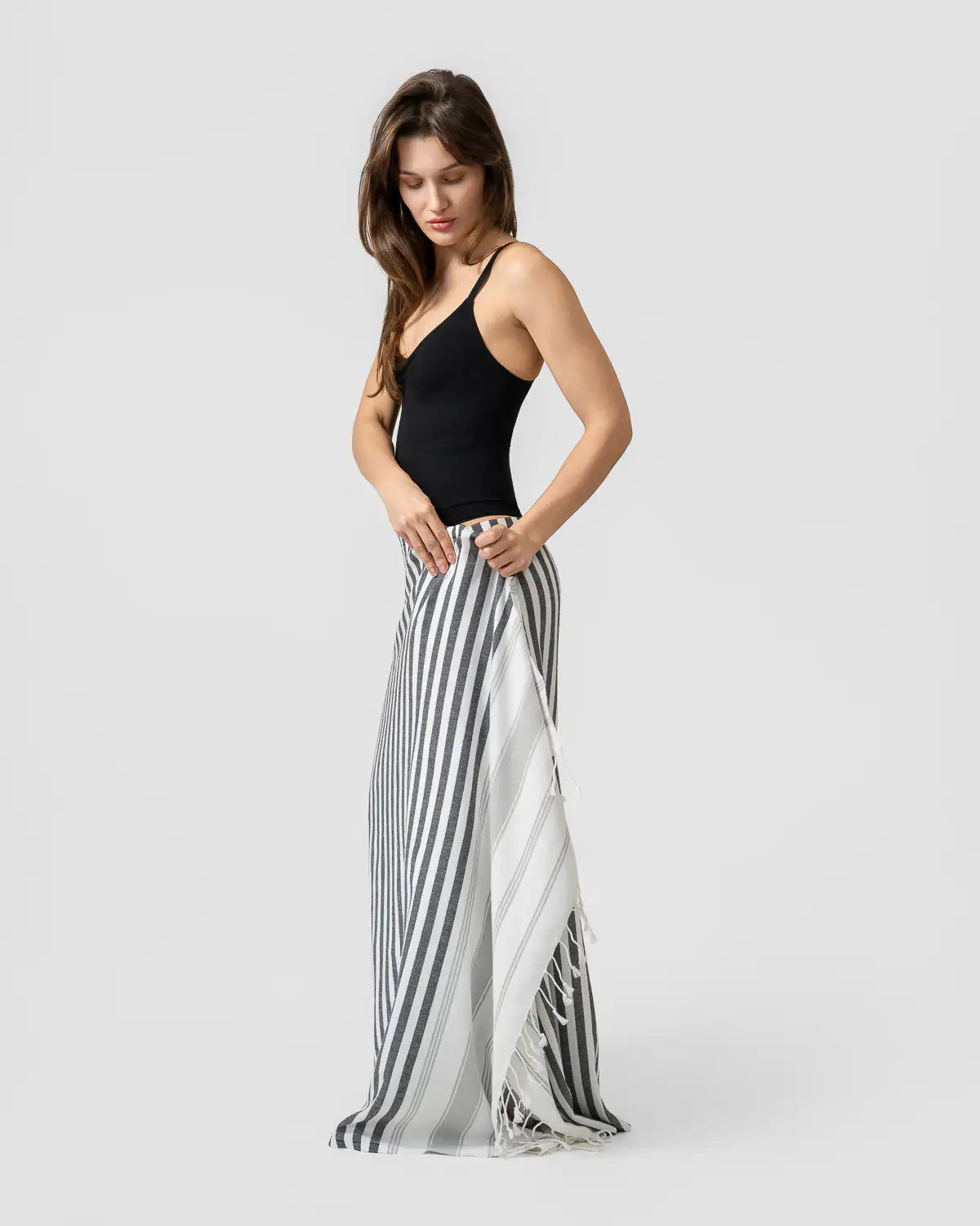 Woman wearing a black top and Ultra-Lightweight Multi-Purpose Beach Towel on a white background