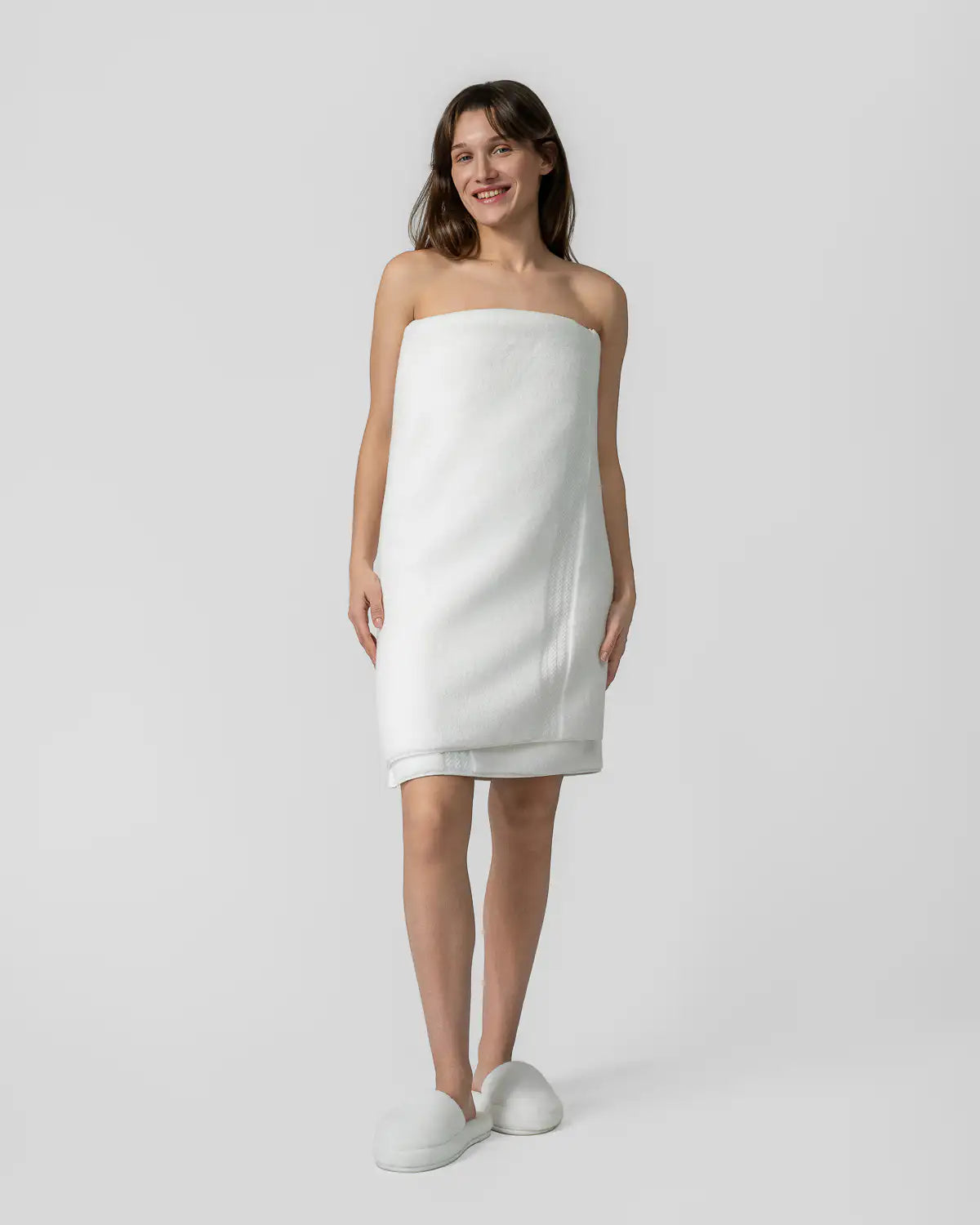 The woman, who has an ultrasoft premium bath towel on, is wearing UltraSoft Cotton High-Absorbency Slippers on her feet.